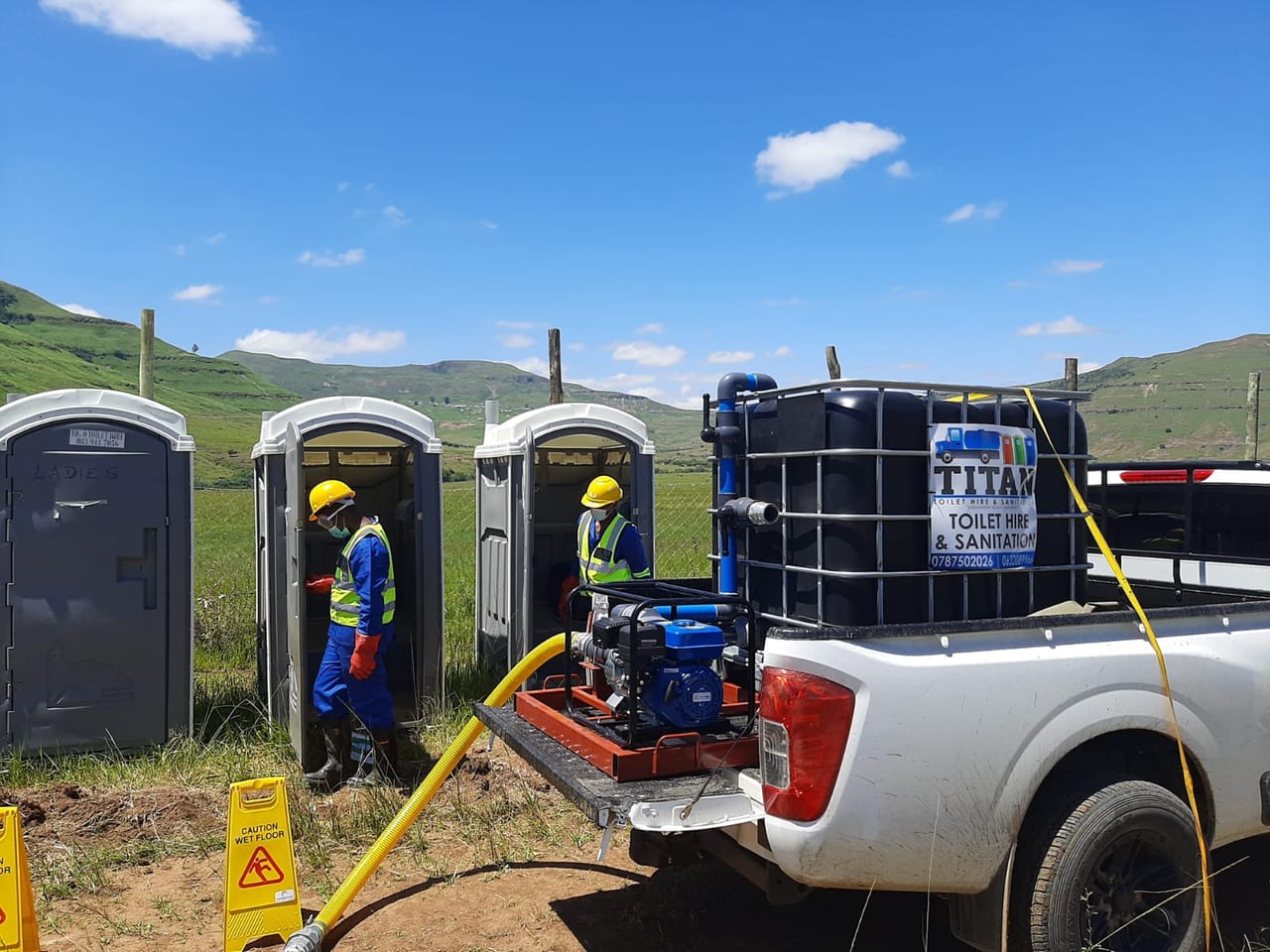 Titan crew working beside the blue portable toilet fleet