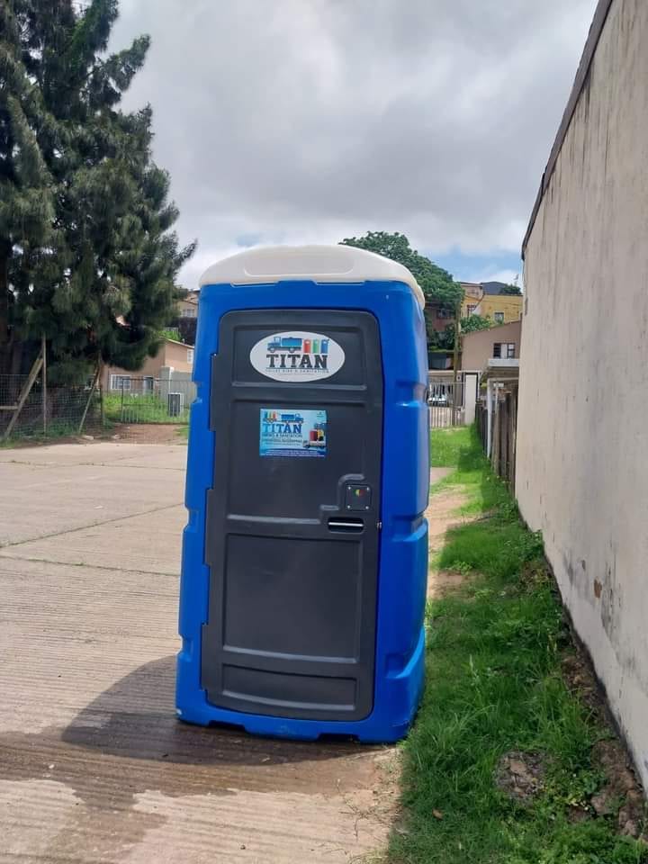 Blue portable toilet with a navy door and pale roof